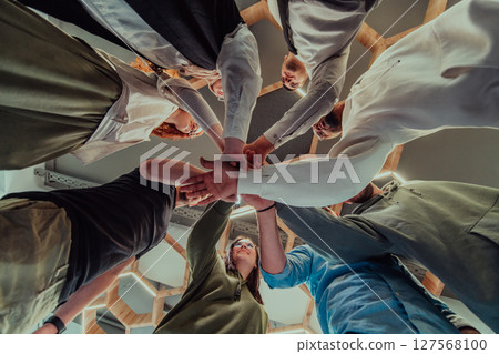A group of young businessmen offer their hands together, symbolizing togetherness in the business world 127568100