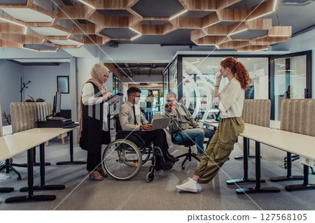 Young group of business people brainstorming together in a startup space, discussing business projects, investments, and solving challenges. 127568105
