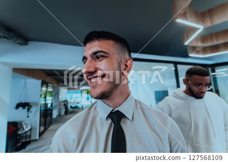 A group of young business professionals stands together, taking a well-deserved break from their busy workday, showcasing camaraderie, teamwork, and a moment of relaxation in their dynamic workplace A group of young business professionals stands together, taking a well-deserved break from their busy workday, showcasing camaraderie, teamwork, and a moment of relaxation in their dynamic workplace 127568109