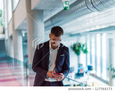 In a sleek corporate setting, the young and charismatic director strides confidently down the hallway, symbolizing his dynamic leadership and the promise of continued success within the company he 127568173
