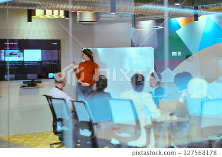 A pregnant business woman with orange hair confidently presents her business plan to colleagues in a modern glass office, embodying entrepreneurship and innovation A pregnant business woman with orange hair confidently presents her business plan to colleagues in a modern glass office, embodying entrepreneurship and innovation 127568178