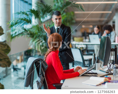 In a modern startup office, a diverse group of young professionals collaboratively tackles various business problems and challenges, surrounded by their engaged colleagues, fostering innovation and 127568263