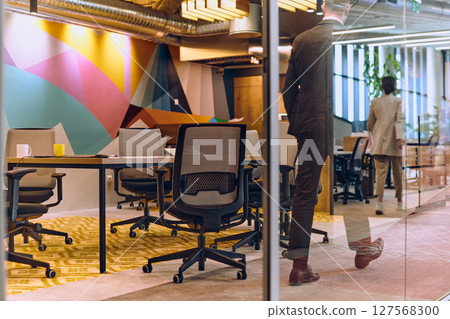 In the vibrant ambiance of a modern startup office, a diverse group of businesspeople gathers around a meeting table, exemplifying teamwork, collaboration, and the dynamic spirit of contemporary 127568300