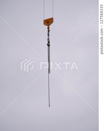 A chain hangs from a crane A chain hangs from a crane 127568335