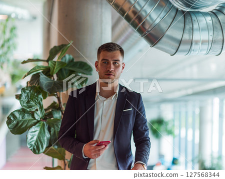 In a sleek corporate setting, the young and charismatic director strides confidently down the hallway, symbolizing his dynamic leadership and the promise of continued success within the company he 127568344