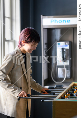 房間裡有桌上足球遊戲的女人 127568429