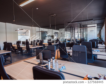 In a setting of modern, glass-walled business startup offices, the open, airy workspace reflects a contemporary and innovative ambiance, promising a dynamic environment for entrepreneurial growth 127568445