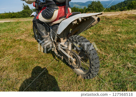 Close up photo of a professional motocross rider in action, showcasing the tire and various components of the motorcycle as they navigate the challenging off-road terrain with speed and precision. Close up photo of a professional motocross rider in action, showcasing the tire and various components of the motorcycle as they navigate the challenging off-road terrain with speed and precision. 127568518