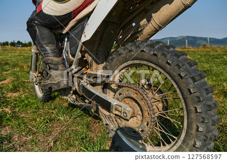 Close up photo of a professional motocross rider in action, showcasing the tire and various components of the motorcycle as they navigate the challenging off-road terrain with speed and precision. Close up photo of a professional motocross rider in action, showcasing the tire and various components of the motorcycle as they navigate the challenging off-road terrain with speed and precision. 127568597
