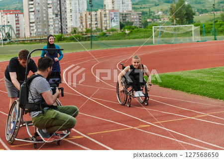 A cameraman filming the participants of the Paralympic race on the marathon course 127568650