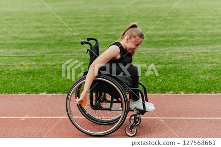 A woman with disablity driving a wheelchair on a track while preparing for the Paralympic Games 127568661