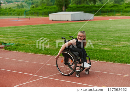 A woman with disablity driving a wheelchair on a track while preparing for the Paralympic Games 127568662
