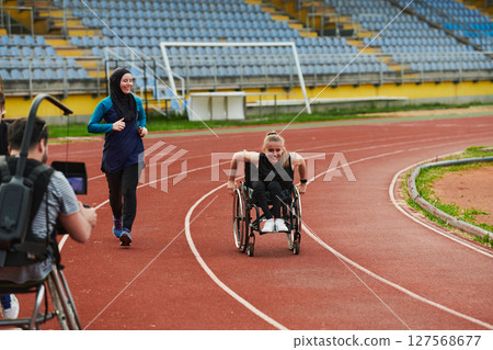 A cameraman filming the participants of the Paralympic race on the marathon course 127568677