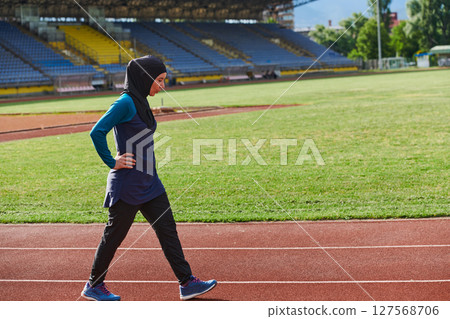 A Muslim woman with a burqa, an Islamic sportswoman resting after a vigorous training session on the marathon course. A hijab woman is preparing for a marathon competition A Muslim woman with a burqa, an Islamic sportswoman resting after a vigorous training session on the marathon course. A hijab woman is preparing for a marathon competition 127568706