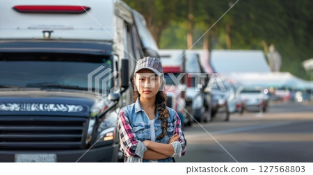 Portrait of a Young Asian Truck Driver with Trucks in the Background.Generated image 127568803