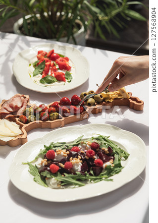 Eating marinated pepper delicacy from platter 127568904