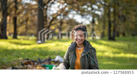 Smiling Young Volunteer Cleaning Up Trash in a Park.Generated image 127568953