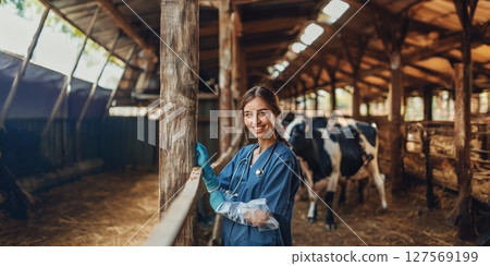 Smiling Young Female Veterinarian in Uniform Caring for Animals on Farm.Generated image 127569199