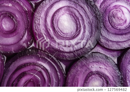 A close-up of fresh red onion slices arranged in a seamless pattern. The purple tones and detailed texture make it ideal for backgrounds, food packaging, food blogs or healthy eating campaigns. Banner 127569482