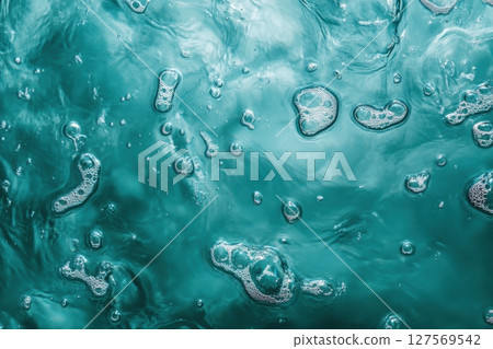 Top view of ocean surface with white sea foam and sun reflections. Clear turquoise water. Natural texture. Clean and refreshing summer atmosphere. Perfect for backgrounds and nature concepts. Banner 127569542