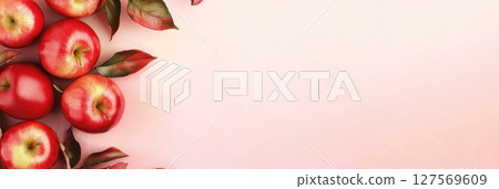Ripe red apples with green foliage arranged on the edges on a soft pink textured surface. Top view, flat lay with empty space in the center. Natural food background for healthy lifestyle concepts. Ripe red apples with green foliage arranged on the edges on a soft pink textured surface. Top view, flat lay with empty space in the center. Natural food background for healthy lifestyle concepts. 127569609