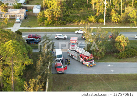 Car crash with first responders helping at accident site on American street. Vehicle collision on road in USA Car crash with first responders helping at accident site on American street. Vehicle collision on road in USA 127570612
