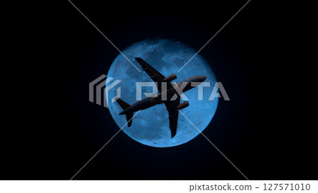 Airplane in the sky. Airplane in flight at sunset or evening sky. Commercial airliner silhouette in the colorful evening or night moon skies. Aircraft symbol of travel adventure global connectivity. Airplane in the sky. Airplane in flight at sunset or evening sky. Commercial airliner silhouette in the colorful evening or night moon skies. Aircraft symbol of travel adventure global connectivity. 127571010