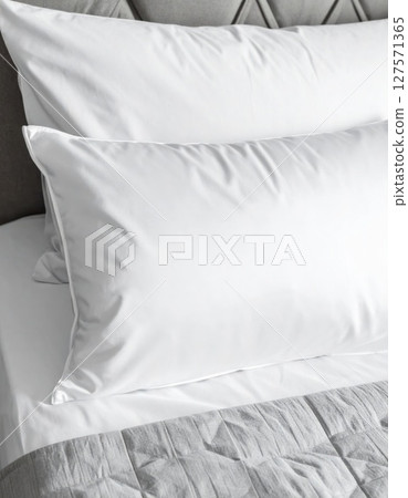 White Pillows on a Grey Bed in a Bedroom 127571365
