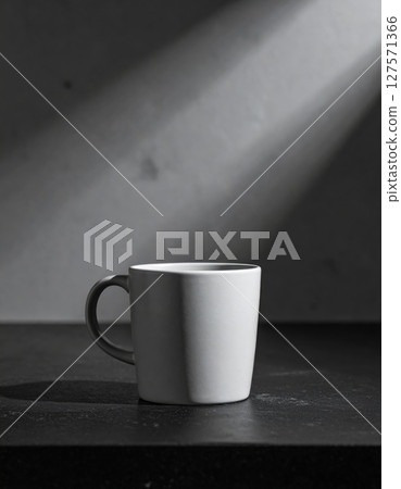 White Ceramic Mug in Dramatic Light on Dark Table 127571366