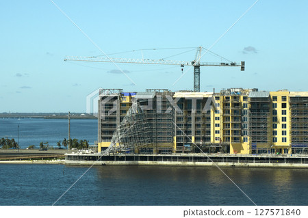 Aerial view of ruined by hurricane Ian construction scaffolding on high apartment building site in Port Charlotte, USA 127571840