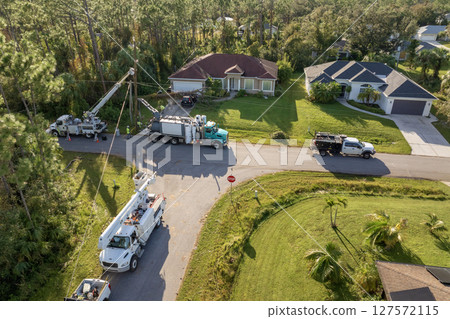 Aerial view of electrician workers repairing damaged power lines after hurricane in Florida suburban area 127572115