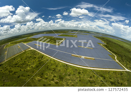 Aerial view of big sustainable electric power plant with many rows of solar photovoltaic panels for producing clean electrical energy. Renewable electricity with zero emission concept Aerial view of big sustainable electric power plant with many rows of solar photovoltaic panels for producing clean electrical energy. Renewable electricity with zero emission concept 127572435