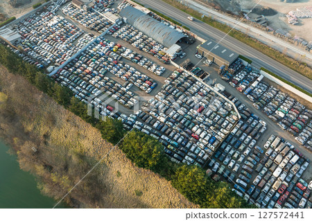 Aerial view of big parking lot of junkyard with rows of discarded broken cars. Recycling of old vehicles 127572441