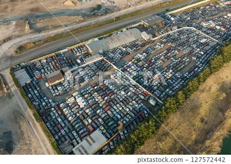 Aerial view of big parking lot of junkyard with rows of discarded broken cars. Recycling of old vehicles 127572442