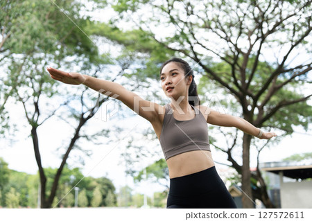 Yoga in nature. Woman practicing a yoga pose with focus and grace in a park. Yoga in nature. Woman practicing a yoga pose with focus and grace in a park. 127572611
