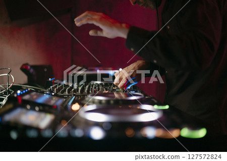 Close up view of a dj's hands playing the mixer while performing Close up view of a dj's hands playing the mixer while performing 127572824