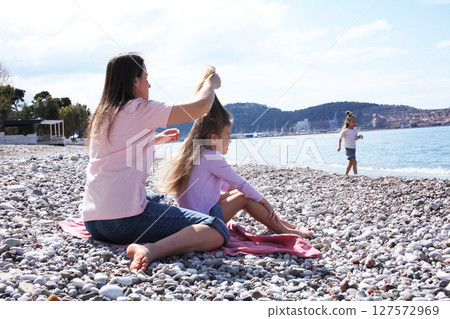 mother with twins daughters on beach mother with twins daughters on beach 127572969