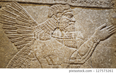 Close-up view on Winged Figure. Architectural Fragment Of Panel From Northwest Palace Of Ashurnasirpal Ii By Neo Assyrian Period. Depicted Is Winged Human Divine Spirit, Protective Spirit. High Priest Close-up view on Winged Figure. Architectural Fragment Of Panel From Northwest Palace Of Ashurnasirpal Ii By Neo Assyrian Period. Depicted Is Winged Human Divine Spirit, Protective Spirit. High Priest 127573261