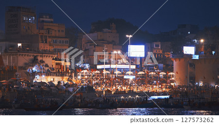 Varanasi, Uttar Pradesh, India. Evening Ganga Maha Aarti ceremony on Dashashwamedh Ghat. night time illumination lights. Cinematic Camera movement moving along riverbank embankment. View from 127573262