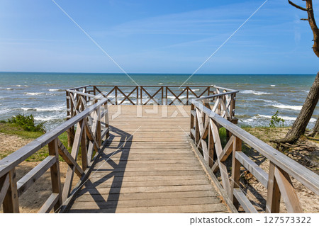 Scenic Baltic Sea viewpoint via rustic wooden railing walkway above shoreline 127573322