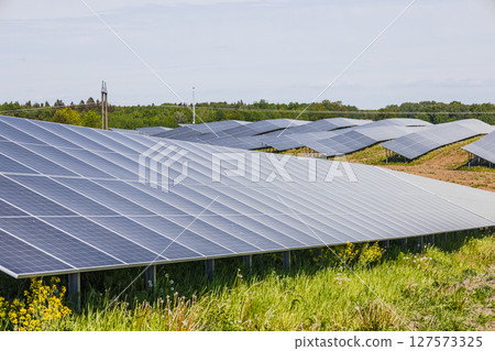 Solar Panel Array on Green Field Generating Renewable Energy from Sunlight Solar Panel Array on Green Field Generating Renewable Energy from Sunlight 127573325