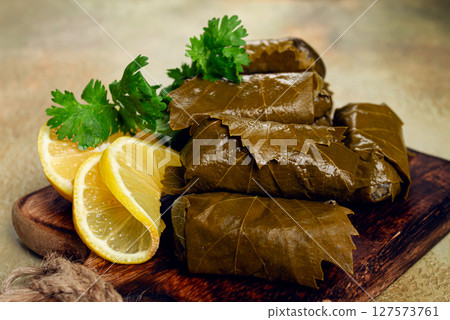 dolma, minced meat with rice, in grape leaves, minced meat rolls, on a chopping board, top view, no people, dolma, minced meat with rice, in grape leaves, minced meat rolls, on a chopping board, top view, no people, 127573761