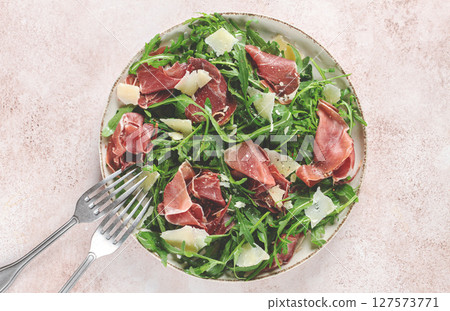 Fresh arugula salad with prosciutto and grated parmesan cheese, on a plate, homemade, no people, Fresh arugula salad with prosciutto and grated parmesan cheese, on a plate, homemade, no people, 127573771