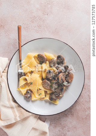 Delicious pappardelle pasta with mushrooms and cream served on a white plate Delicious pappardelle pasta with mushrooms and cream served on a white plate 127573785