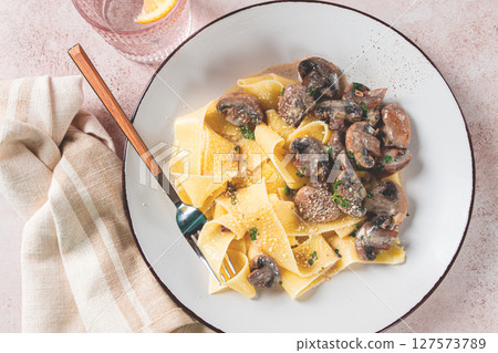 Delicious pappardelle pasta with mushrooms and cream served on a white plate 127573789