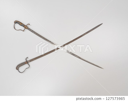Two old fashioned swords are crossed over each other Two old fashioned swords are crossed over each other 127573985