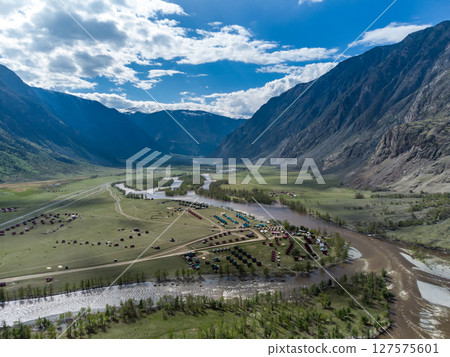 Summer landscape in the Chulyshman mountain valley. Winding mountain river, green alpine meadows and beautiful mountains. Summer landscape in the Chulyshman mountain valley. Winding mountain river, green alpine meadows and beautiful mountains. 127575601