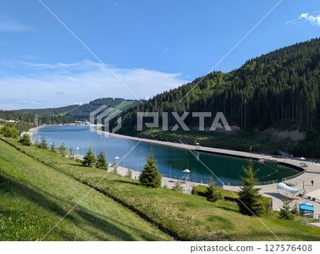 Beautiful lake among pine forest in the mountains Beautiful lake among pine forest in the mountains 127576408