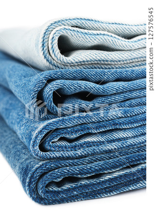 Pile of textiles in various shades of blue, stacked jeans fabric on top of each other in store Pile of textiles in various shades of blue, stacked jeans fabric on top of each other in store 127576545