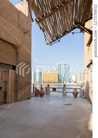 Old town in Al Seef Cultural Historical District on shores of Dubai Creek. Tourist place with old streets, houses and shops, Dubai, UAE. Vertical photo Old town in Al Seef Cultural Historical District on shores of Dubai Creek. Tourist place with old streets, houses and shops, Dubai, UAE. Vertical photo 127576652